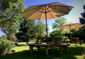Glorious sunny day in the garden with an umbrella up over a round wooden table